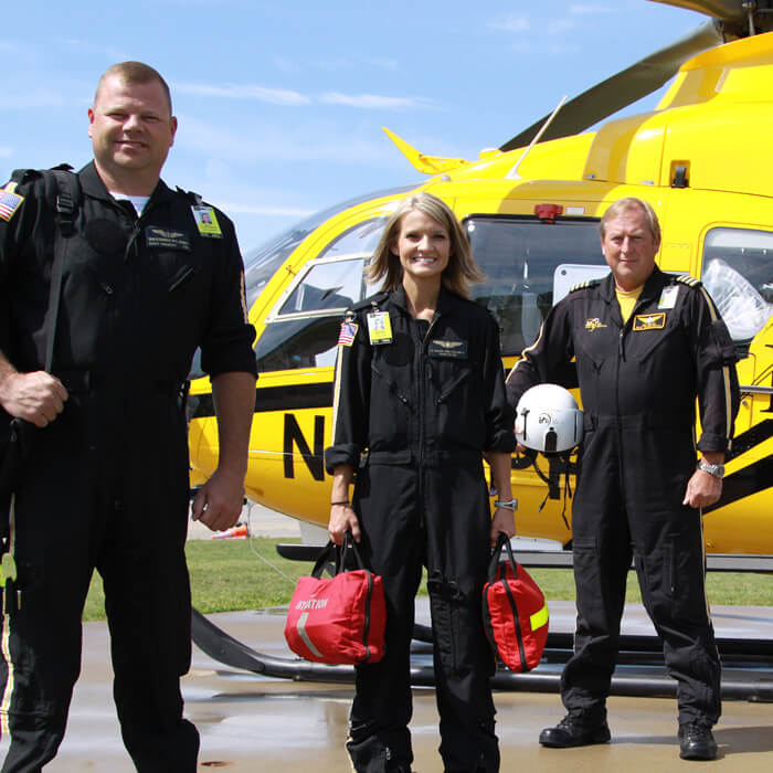 PHI employees in front of helicopter